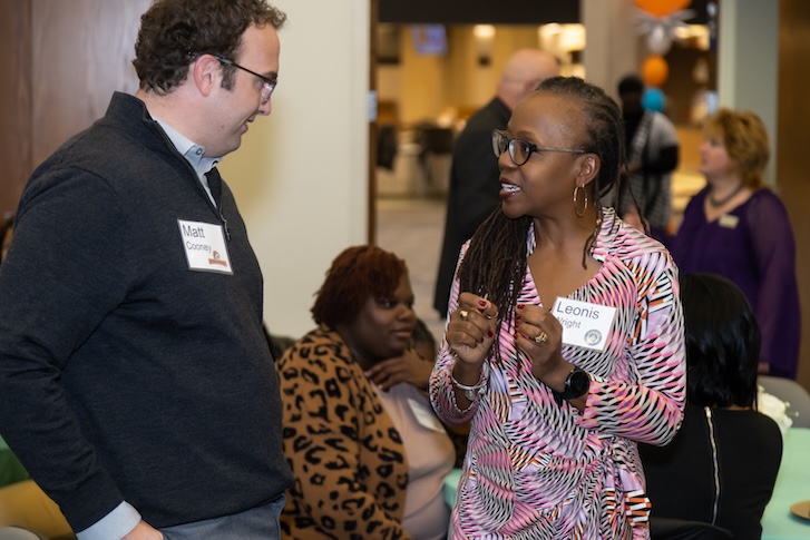 Faculty members talking to each other during event